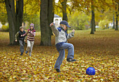 Children playing football in park