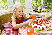 Happy girl with big strawberry cake