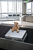 Suitcase and teddy bear on baggage conveyor belt, Munich airport, Bavaria, Germany