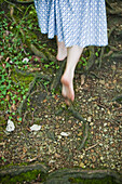 Barefoot woman walking across forest floor, Bavaria, Germany