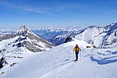 Female backcountry skier ascending Hocheisspitze, Granatspitz mountain range, Hohe Tauern, Salzburg, Austria