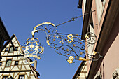 Wrought iron guild sign in front of  a half-timbered house, Rothenburg ob der Tauber, Bavaria, Germany