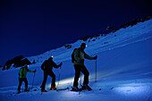 Three men backcountry skiing at night, ascent to hut Staufner Haus at Hochgrat with view to Hochgrat, Hochgrat, Nagelfluh range, Allgaeuer Alpen range, Allgaeu, Bavaria, Germany