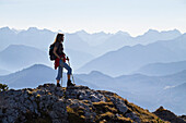 Frau beim Bergwandern am Brauneck, Karwendel im Hintergrund, Oberbayern, Bayern, Deutschland