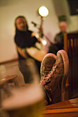 Man with sneakers on table and musicians aboard cruiseship in the evening, South Atlantic Ocean, South America, America