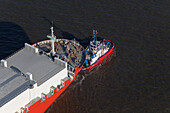 Aerial view of a freighter being towed into the harbour, Bremerhaven, northern Germany