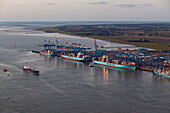 Aerial view of the container port, Containers, loading cranes and ships along the quai, coastal wind turbines in the background, Bremerhaven, Lower Saxony, northern Germany