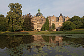 Blick über den Wassergraben zum Bückeburger Schloss, Schloss Bückeburg spiegelt sich im Wasser, Seerosen, Bückeburg, Niedersachsen, Deutschland