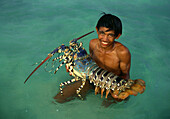 Boy in the water holding giant pacific lobster, Cebu Island, Visayas, Philippines, Asia