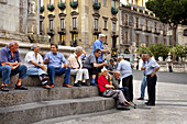 Männer auf dem Piazza Duomo, Catania, Sizilien, Italien