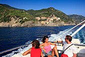 Familie auf Ausflugsschiff, Blick vom Meer auf Manarola, Bootsfahrt entlang der Küste, Cinque Terre, Ligurien, Italienische Riviera, Italien, Europa