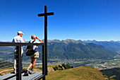 Mann blickt mit Fernglas von der Kapelle Santa Maria degli Angeli (Architekt: Mario Botta), Alpe Foppa, Bergwanderung zum Monte Tamaro, Tessin, Schweiz