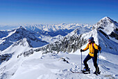 Woman backcountry skiing, ascending to Magerstein, Rieserferner range and Zillertaler Alpen range in the background, Magerstein, Rieserferner range, South Tyrol, Italy
