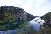 Fluss und Uferlandschaft unter Wolkenhimmel, Kroatien, Europa