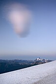 Odd shaped cloud hovering in the evening light above Mount Shuksan, seen from Chowder Ridge Mount Baker Wilderness Washington USA