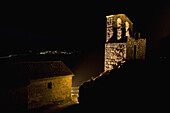 Night view of the San Juan Bautista Chuch with the Trevejo lights behind  Trevejo  Villamiel  Sierra de Gata  Caceres province  Extremadura  Spain