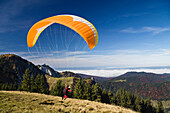 Gleitschirmflieger auf dem Brauneck bei Lenggries, Alpen, Oberbayern, Deutschland