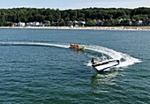 People on motor boat and banana boat, Baltic resort Binz, Ruegen, Mecklenburg-Western Pomerania, Germany, Europe