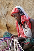 Ethiopia, Afar region, Ahmedila village, Young Afar woman weaving a mat