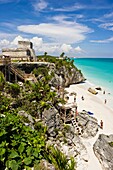 El Castillo The Castle and rocky beach with sunbathers at the Mayan ruins of Tulum in Quintana Roo, Mexico
