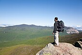 A hiker enjoys the views from the summit of Mount Liberty during the summer months  Located in the White Mountains, New Hampshire USA