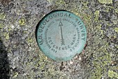 Us Geological Survey Marker on the summit of Mount Isolation during the summer months in the scenic landscape of the White Mountains, New Hampshire USA