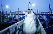Bride and groom with gondolas at San Marco Pier and San Giorgio Maggiore in background  Venice  Veneto, Italy