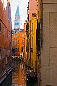 Small canal with Campanile bell tower in the background in Venice Italy Europe