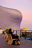 Woman reading outside Selfridges department store Bullring shopping centre Birmingham England UK Europe