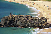 Menschen auf einem Felsen am Strand, Weimea Bay Beach Park, North Shore, Oahu, Hawaii, USA, Amerika