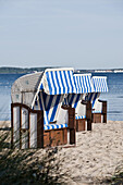 Roofed wicker beach chairs at beach of Wohlenberg, Boltenhagen, Bay of Mecklenburg, Mecklenburg-Vorpommern, Germany