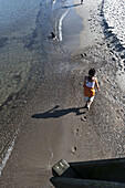Frau läuft am Strand entlang, Heiligendamm, Bad Doberan, Mecklenburg-Vorpommern, Deutschland