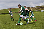 Junge spielen Fussball, County Clare, Irland