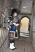 Bagpiper in front of the entrance to Bunratty Castle, County Clare, Ireland