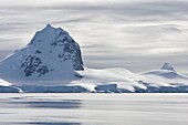 The Lindblad Expeditions ship National Geographic Explorer pushes through ice in Grandidier Channel, a navigable channel between the west coast of Graham Land and the north end of the Biscoe Islands, extending from Penola Strait southwestward to the vicin