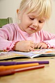 Stock photo of a four year old girl drawing pictures on a piece of paper