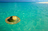 Tanzania. Mnemba Island. Lost hat floating in the clear waters of the Indian Ocean