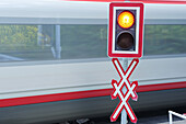 Bahnübergang mit Andreaskreuz und fahrendem Zug im Hintergrund, Semmeringbahn, UNESCO Weltkulturerbe Semmeringbahn, Niederösterreich, Österreich