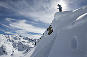 Skifahrer steht auf Wechte, Pischa, Davos, Kanton Graubünden, Schweiz