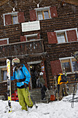 Skifahrer vor Berghütte Alte Schwendi, Klosters-Serneus, Kanton Graubünden, Schweiz
