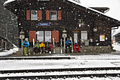 Skifahrer warten am Bahnhof, Cavadürli, Klosters-Serneus, Kanton Graubünden, Schweiz