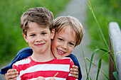 Zwei Jungen (6 - 7 Jahre) lächeln in die Kamera