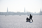 Stroller with buggy on frozen outer Alster in winter, Hamburg, Germany
