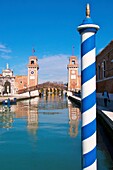 Arsenal entrance towers and canal, in the foreground ,  paline, mooring post, Venice, Italy