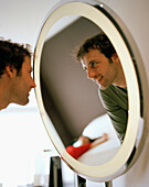 Mann schaut im Hotelzimmer in einen Spiegel, Madrid, Spanien
