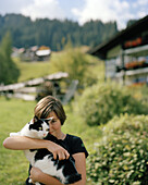 Mädchen schmust mit Katze, Naturhotel Chesa Valisa, Hirschegg, Kleinwalsertal, Österreich