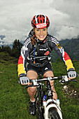 Woman on mountain bike at Eggen alp, Reit im Winkl, Bavaria, Germany, Europe