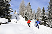 People hiking on winter hiking trail in snowy landscape, Hemmersuppenalm, Reit im Winkl, Chiemgau, Bavaria, Germany, Europe
