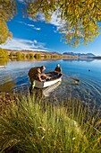 Trout fishermen set out for a morning's fishing in rowing boat no engines allowed on lake Lake Alexandrina Wildlife Refuge, Mackenzie country, Canterbury