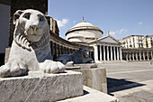 Stone carved lions on the Piazza del Plebiscito with Church of San Francesco di Paola in the background. Naples. Campania. Italy